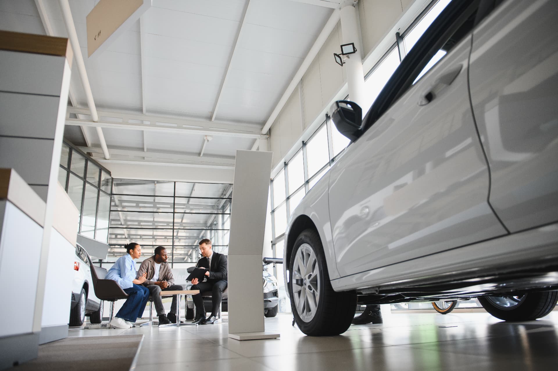 A couple discussing a vehicle purchase at a dealership